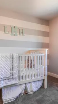 Vertical frame Interior of a nursery with white crib and monogram letters on the Stock Photos