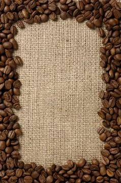 Vertical frame made from aromatic coffee beans on sacking fabric background Stock Photos