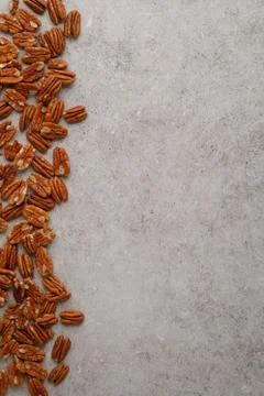 Vertical frame photo of pecan nuts on marble table Stock Photos