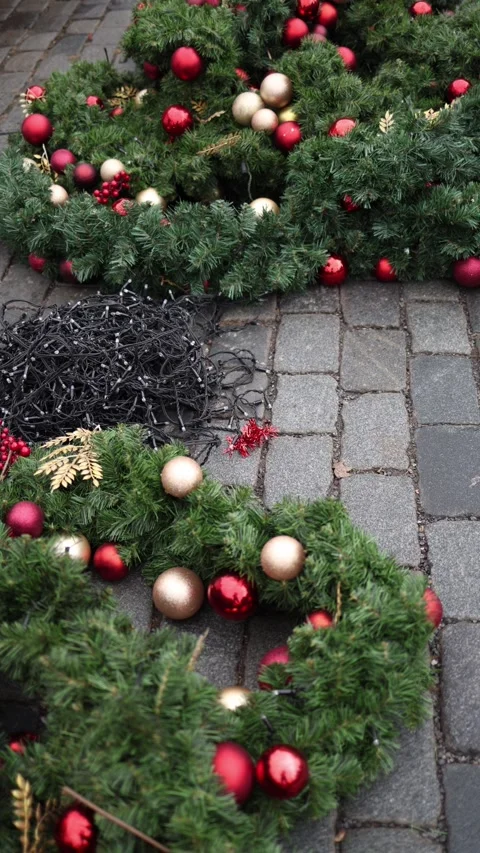 Vertical frame showcasing festive wreaths adorned with red and gold ornaments, p Stock Footage 297265097