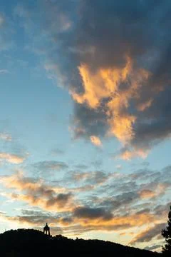 Vertical frame of a sunset sky with billowing orange lit clouds rising above a Stock Photos