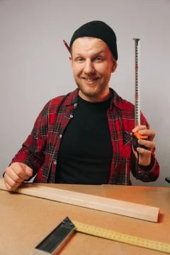 Vertical frame , young Caucasian guy a carpenter with a beard works in a carp Stock Photos
