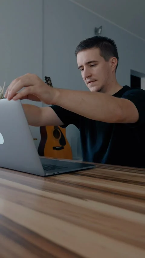Vertical of Freelancer opens laptop to continue writing article at table Stock Footage 274153287