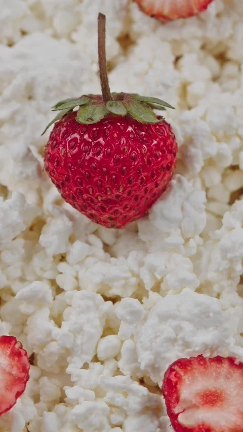 Vertical fresh cottage cheese topped with whole and sliced strawberries Stock Footage 318474585