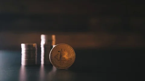 Vertical front view closeup of golden bitcoin on pile of metallic coins on dark Stock Footage 87280122
