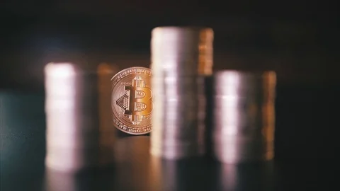 Vertical front view closeup of golden bitcoin on pile of metallic coins on dark Stock Footage 87281703