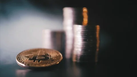 Vertical front view closeup of golden bitcoin on pile of metallic coins on dark Stock Footage 87281795