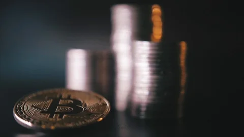 Vertical front view closeup of golden bitcoin on pile of metallic coins on dark Stock Footage 87281855