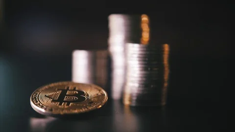 Vertical front view closeup of golden bitcoin on pile of metallic coins on dark Stock Footage 87304504