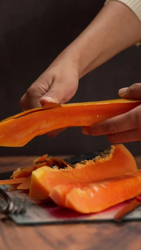 Vertical fruit video, The hands of a Latina woman removing the papaya peel Stock Footage 328896597