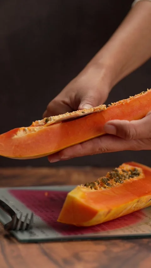 Vertical fruit video, the hands of a Latina woman removing papaya seeds Stock Footage 328896600