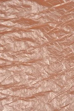 A vertical full frame texture shot of a wrinkled brown plastic film backgroun Stock Photos