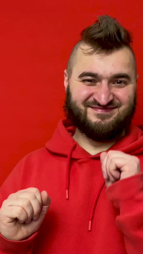 Vertical Full HD video. Young adult bearded man dances on scarlet background Stock Footage 277421363