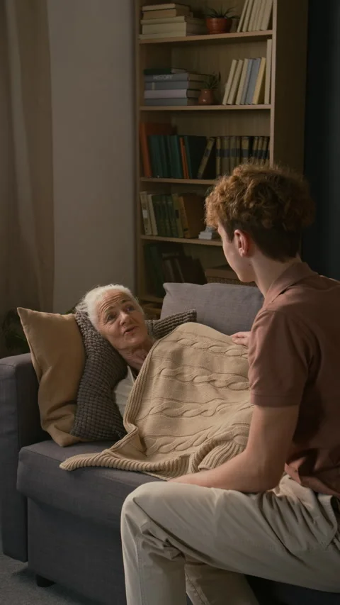 Vertical of Gen Z Boy Taking Care of Unwell Grandmother in Living Room Stock-Footage 329176130