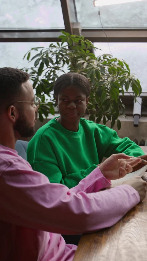 Vertical of Gen Z Couple Reading Restaurant Menu and Deciding What to Order Stock Footage 333263830