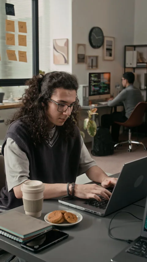Vertical of Gen Z Male Software Engineer Coding on Laptop at Wooden Desk Stock Footage 329611115