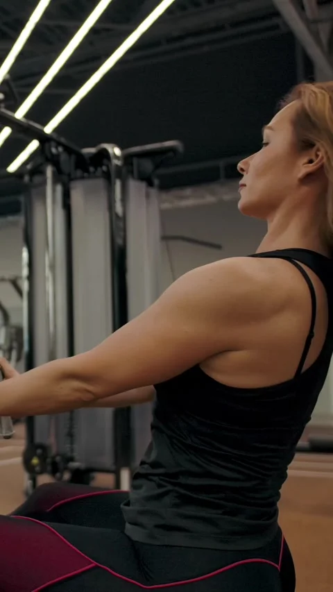 Vertical of The girl does exercises at exercise machine for the muscles of the Stock Footage 276923158