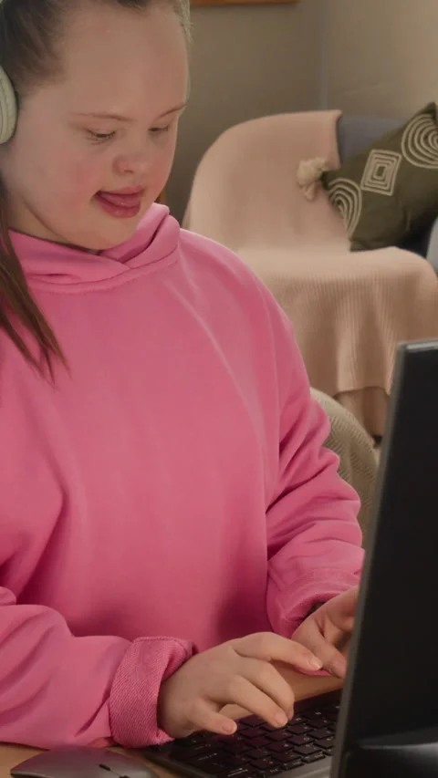Vertical of Girl with Down Syndrome Having Fun while Playing Videogame on PC Stock Footage 334358607