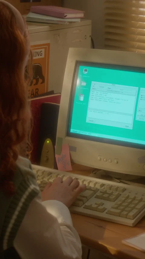 Vertical of Girl Typing on Vintage Computer Using Retro Chat Program 動画素材 343651541