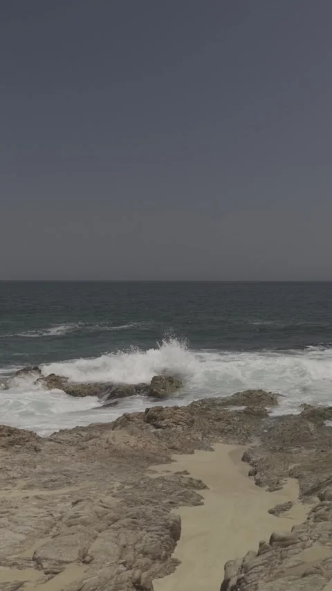 Vertical Glide Out to Sea Waves &amp; Rocks Stock Footage 285564390