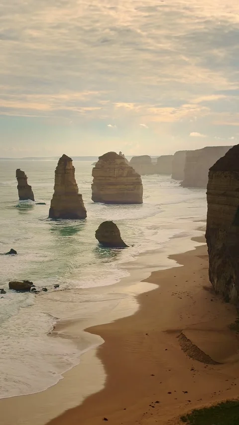 Vertical golden hour view of the Twelve Apostles sea stacks and beach Stock Footage 345293236