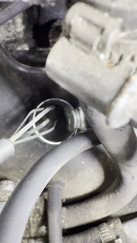 Vertical - A grab tool picking up a dropped hose clip from an engine bay. Video stock 304751917