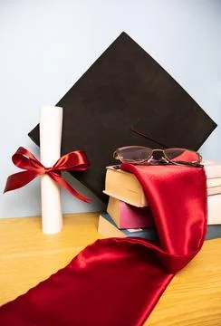 Vertical graduation background with academic hat stole diploma and stack of.. Stock Photos