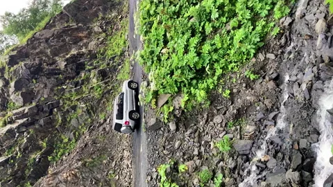 Vertical: Gray car driving dangerous rocky road on edge of mountain range 스톡 동영상 233346768