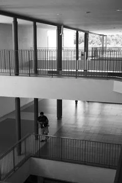 Vertical grayscale shot of a building interior with different floors and a male Fotos de archivo