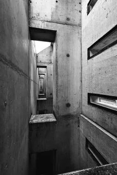 A vertical grayscale shot of sequenced building columns rectangular holes and Foto stock
