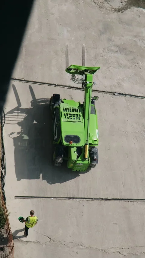 Vertical: Green Heavy Machinery Operating at Construction Site. Worker behind Stock Footage 280689161