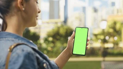 Vertical green screen chroma key on mobile phone held by woman Stock Photos
