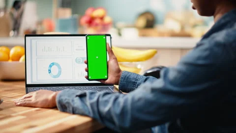 Vertical green screen on mobile phone near laptop with analytics data Stock Footage 344248383