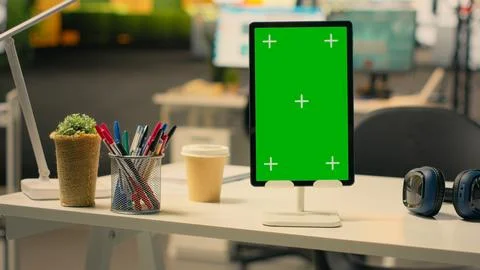 Vertical green screen on tablet at empty business workstation with stationery Stock Photos
