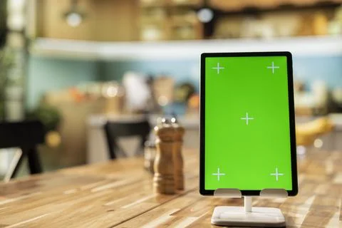 Vertical green screen on tablet in empty rustic kitchen table Stock Photos