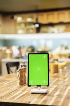 Vertical green screen on tablet in empty wooden stylish kitchen space Stock Photos