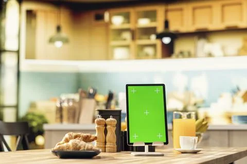 Vertical green screen on tablet in empty modern kitchen space Stock Photos