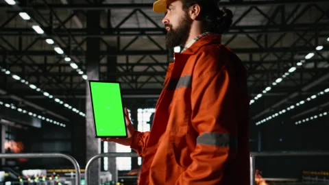 Vertical green screen on tablet held by male engineer in heavy industry plant Stock Footage 330086757