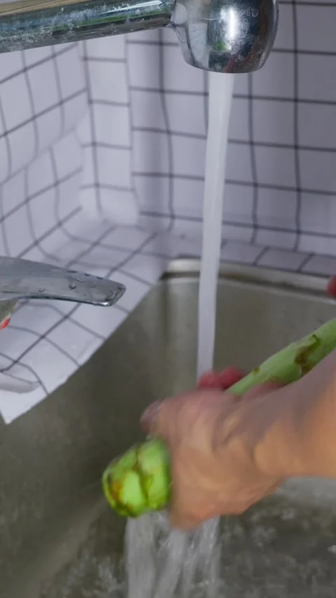 Vertical: Green vegetables get rinsed under running tap water Видео 341837277