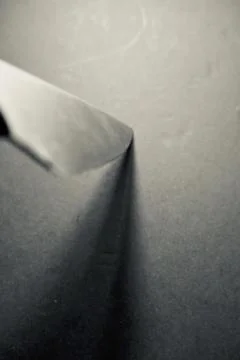 Vertical grey scale shot of a sharp knife pointing at a grey surface Stock Photos