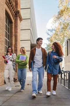 Vertical. Group of smiling high school teenage students walking before starting Stock Photos