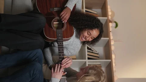 Vertical guitar lesson beloved couple home Stock Footage 234404452
