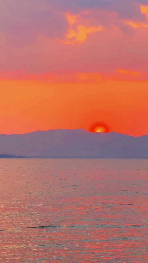 Vertical  Half Sun Peeking over Cangshan Mountains at Erhai Lake Video stock 332474392