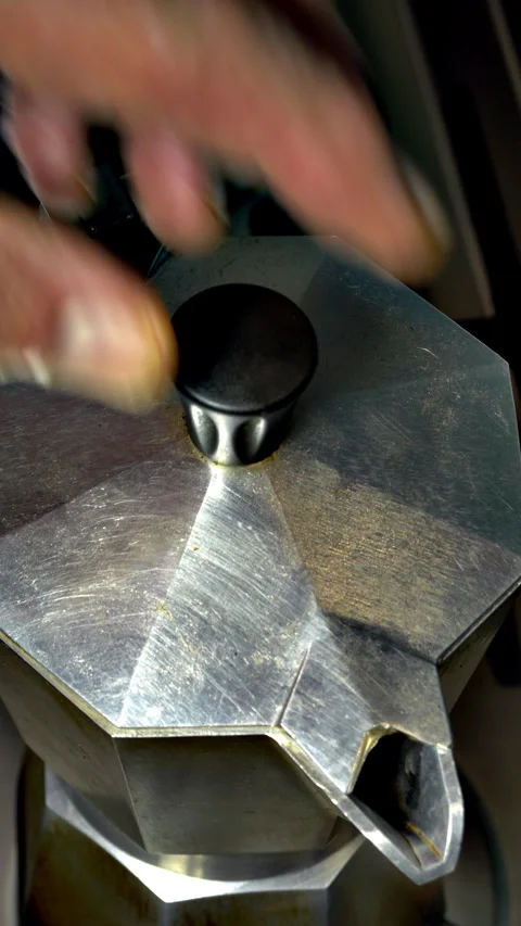Vertical - A hand closing the lid on a stove top coffee pot, as brewing ends. Stock-Footage 283395672