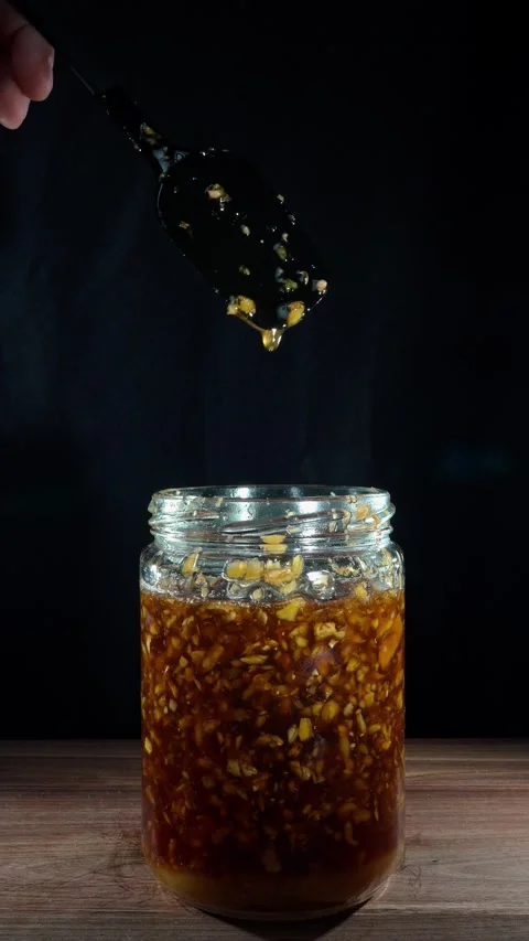 Vertical Hand Grabbing and Removing Fermented Ginger Jar from Table Stock Footage 324921041