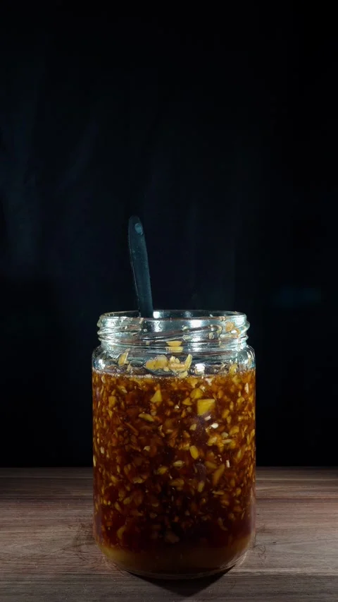 Vertical Hand Removing Fermented Ginger Honey Jar with Ladle from Table Stock Footage 324921083