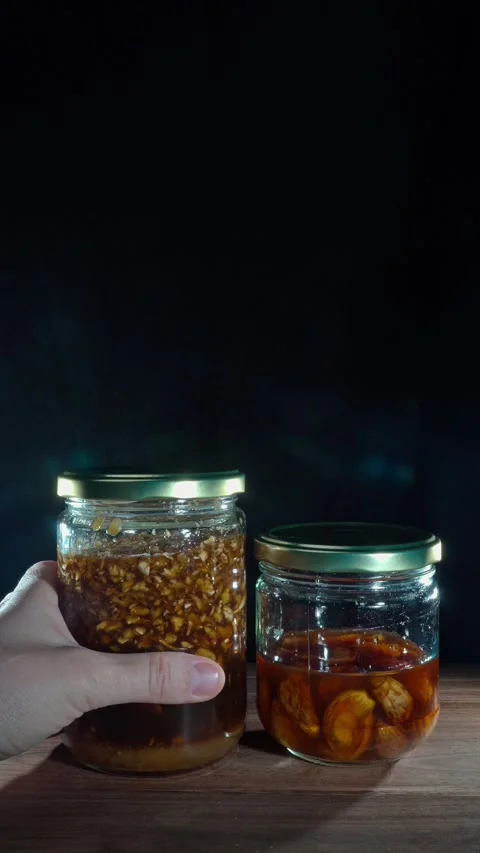Vertical Hand Removing Ginger And Garlic Honey Jars Clearing Frame Stock Footage 324922196
