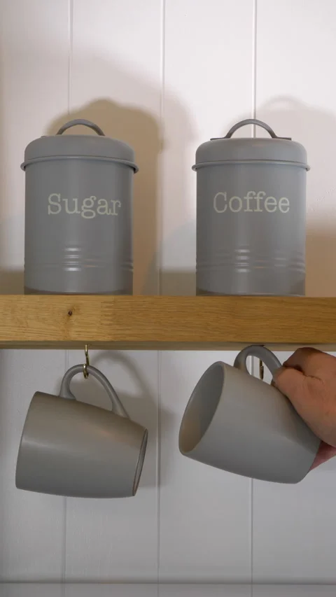 Vertical - A hand removing a hanging mug then a coffee container from a shelf. Vídeos de archivo 288336316