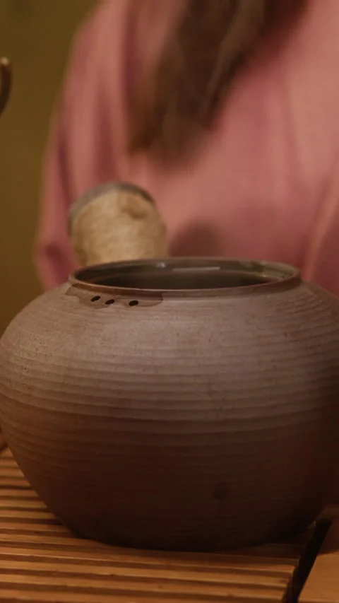 Vertical of Hand of Tea Ceremony Master Warming Clay Teapot with Hot Water Stock Footage 326610911