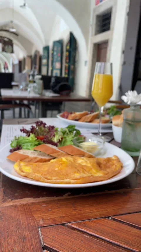 Vertical handheld pan across brunch table highlighting avocado toast omelet Stock Footage 341626294